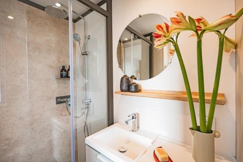 a bathroom with a sink and a shower with a mirror at Campasun Camping de l'Aigle in Aiguines