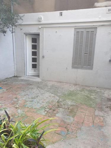 - un bâtiment blanc avec une porte et une fenêtre dans l'établissement Joli Appartement chaleureux proche des transports pour accès rapide au vieux port, à Marseille