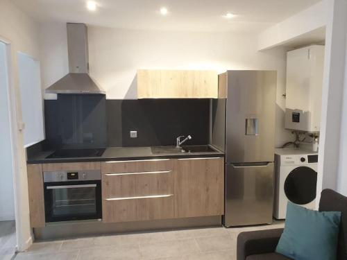 une cuisine avec un réfrigérateur en acier inoxydable et un évier dans l'établissement Joli Appartement chaleureux proche des transports pour accès rapide au vieux port, à Marseille