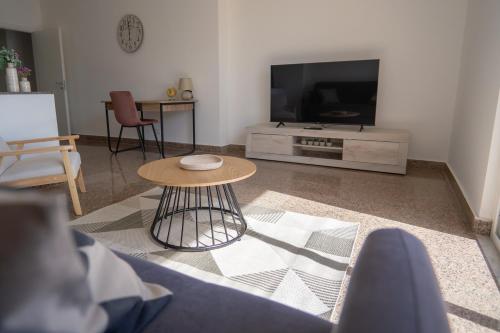 a living room with a table and a tv at Casa Erika in Bova Marina