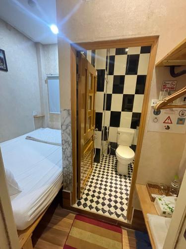 a small bathroom with a bed and a toilet at Winny Hotel in Can Tho