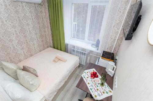 a small room with a bed and a window at Отличная студия в центре in Almaty