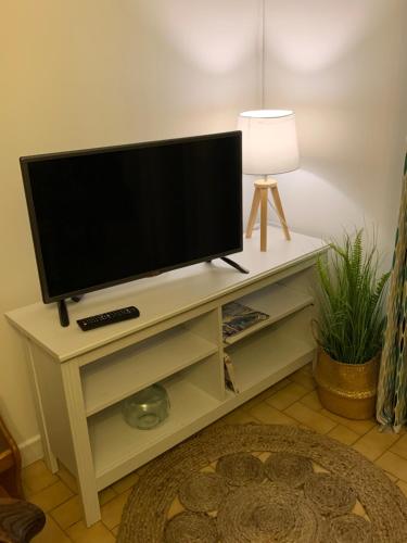 TV en un puesto blanco en la sala de estar en Gîte chez Emy et Seb, en Privas