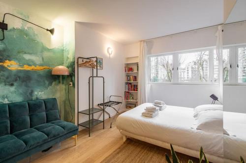 une chambre avec un lit, un canapé et une fenêtre dans l'établissement Couronnes - Cosy studio tout équipé et privatif, à Paris