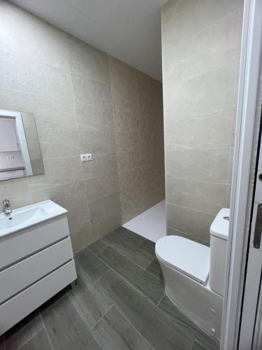 a bathroom with a white toilet and a sink at Apartamentos BEACHYDAYS Metropolis B in Torremolinos
