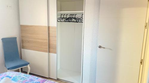 a glass door in a bedroom with a blue chair at PLAZA ANDALUCIA APARTMENT - Con Encanto in Córdoba