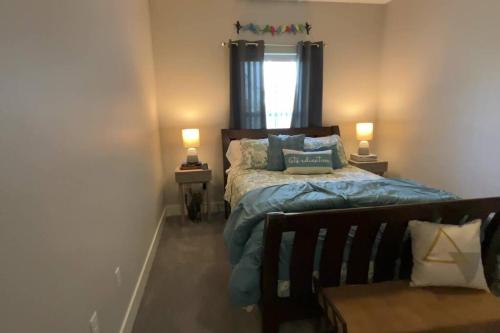 - une chambre avec un lit doté de draps bleus et une fenêtre dans l'établissement Main Floor New Charming 2 Bedroom Condo, à Bettendorf
