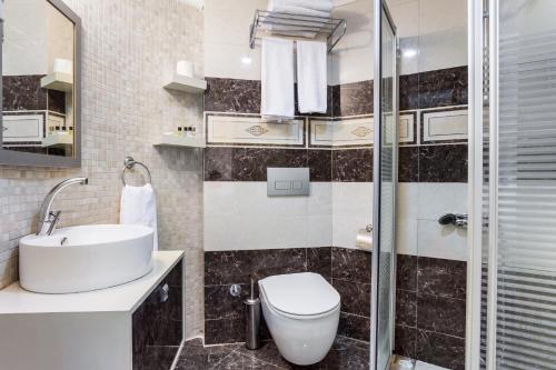 Un baño con inodoro, lavabo y ducha. en Ayhan Hotel, en Antalya