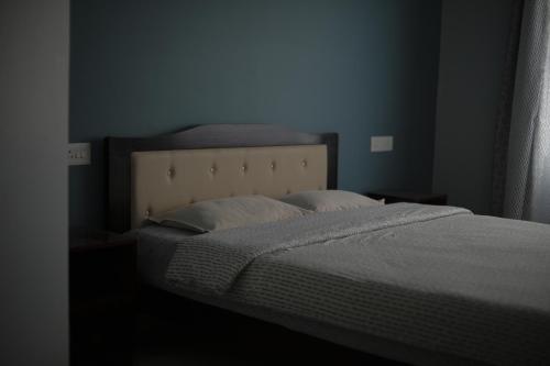a bed in a bedroom with a blue wall at Cafe Sola bnb in Shillong