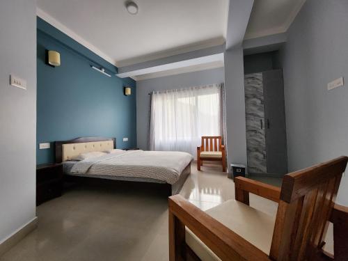 a bedroom with a bed with a blue wall at Cafe Sola bnb in Shillong