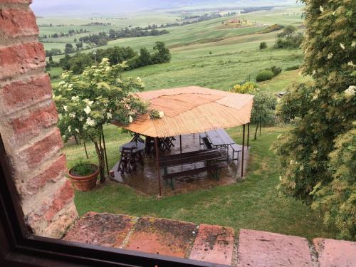 a view of a gazebo in a field from a window at Villa Fonte all'Oppio con area piscina recintata in Pienza