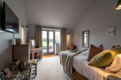 a bedroom with a bed and a desk and a television at The Welldiggers Arms in Petworth