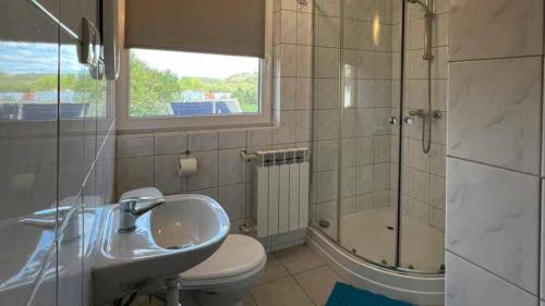 La salle de bains est pourvue d'un lavabo, d'une douche et de toilettes. dans l'établissement Kwatery u Papieżów, à Biały Dunajec