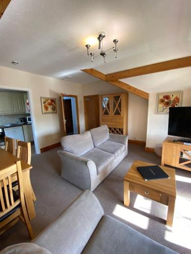a living room with a couch and a table at Garnett - Comfy apartment, great location! in Clitheroe