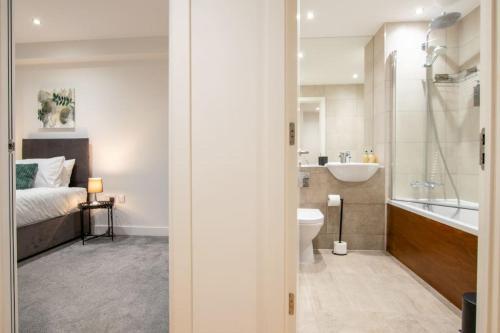 y baño con cama, bañera y lavamanos. en Luxury City Centre Apartment (Weekly Booking), en Hull