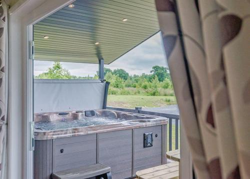 an outside view of a tub on a porch at Woodhall Country Park Lodges in Woodhall Spa