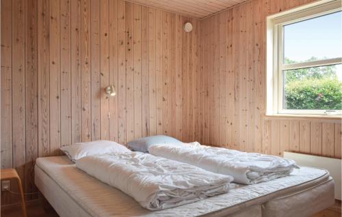 FæbækにあるAmazing Home In Tranekr With 2 Bedrooms And Wifiのウッドウォールと窓が備わるドミトリールームのベッド2台分です。