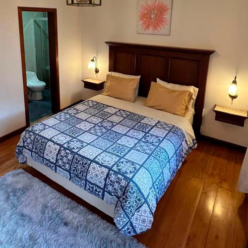 a bedroom with a bed with a blue and white quilt at Casa Hibiscus Boutique Hotel in Cuenca
