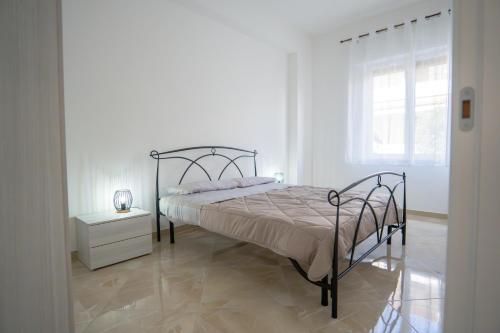 a white bedroom with a bed and a window at Casa Erika in Bova Marina