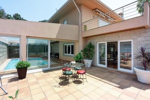 a house with a patio with a table and chairs at Villa Jobim in Juvim