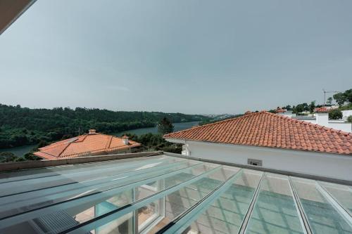 a glass roof on a building with a view of a river at Villa Jobim in Juvim