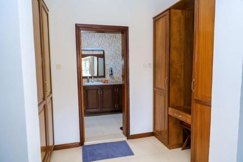 a hallway with a mirror and a door to a bathroom at a vacation home in Mbweni