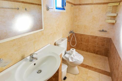 a bathroom with a sink and a toilet at Pavlis Studios Kampos in Marathokampos