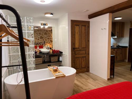 a bathroom with a bath tub and a kitchen at La Mansión de La Adrada in La Adrada