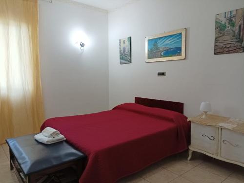 una camera con un letto con copriletto rosso di B&B CASA NISI a Villa Castelli