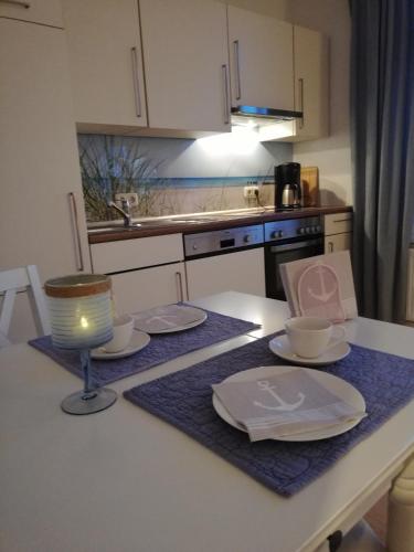 a kitchen with a table with plates and a lamp at Heimathafen 1 in Grevesmühlen