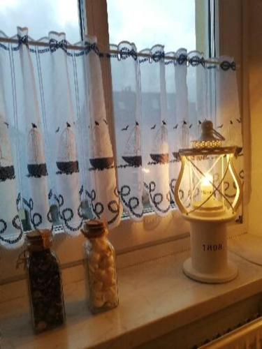 a window with a lamp and two jars on a window sill at Heimathafen 1 in Grevesmühlen