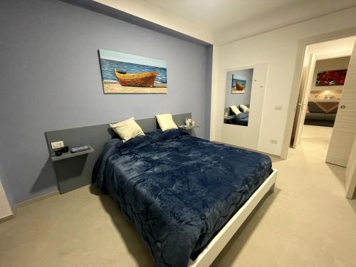 a bedroom with a bed with a blue comforter at Regina Elena Home in Portopalo
