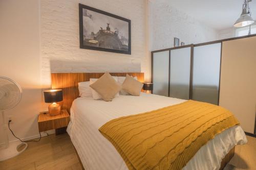1 dormitorio con 1 cama grande con manta amarilla en My Place Donceles, en Ciudad de México