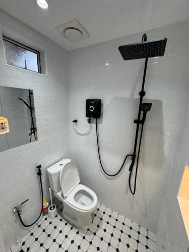 een badkamer met een toilet en een douche. bij HOMESTAY SCANDINAVI at BUKIT MERTAJAM PENANG in Kubang Semang
