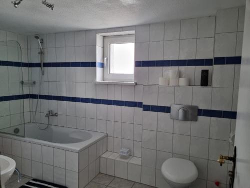 a bathroom with a tub and a toilet and a sink at Fewo-O3-4-6-Personen-23km-bis-Frankfurt-Nord in Ober-Mörlen