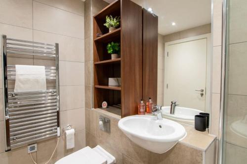 La salle de bains est pourvue d'un lavabo, de toilettes et d'un miroir. dans l'établissement Luxury City Centre Apartment (Weekly Booking), à Hull