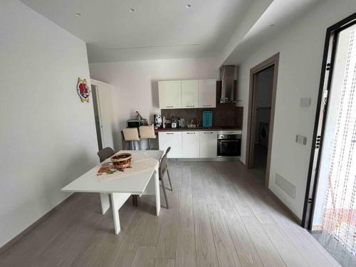 una cucina bianca con tavolo bianco e una camera di La Casa di nonna Elena ad Agerola
