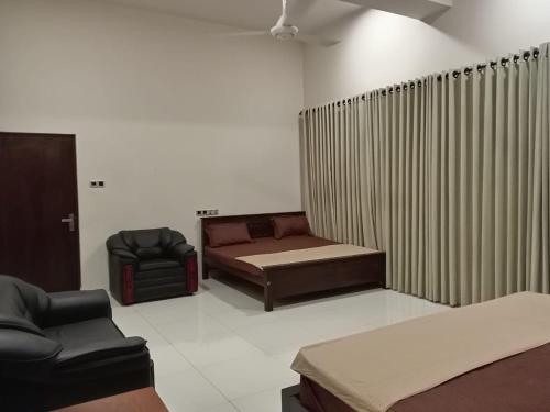 a room with a bed and a couch and a chair at Thalangama Lakeview Lodge in Battaramulla