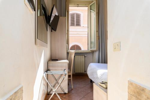 ローマにあるホテル ジュリアのベッド1台とテレビが備わる小さな客室です。
