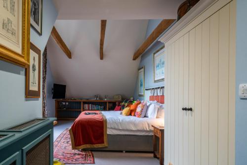 a bedroom with a bed with orange pillows at The Anchor Inn in Lower Froyle