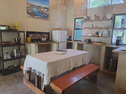 a kitchen with a table and a counter with a refrigerator at Shangrila-innibos Country Lodge in Hartbeespoort