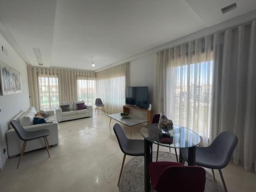 a living room with a couch and a table at Appartement à louer avec une vue panoramique sur le parc prestigia fes in Fès