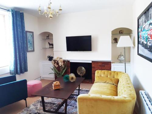 a living room with a yellow couch and a table at Pulteney Road Apartment in Bath