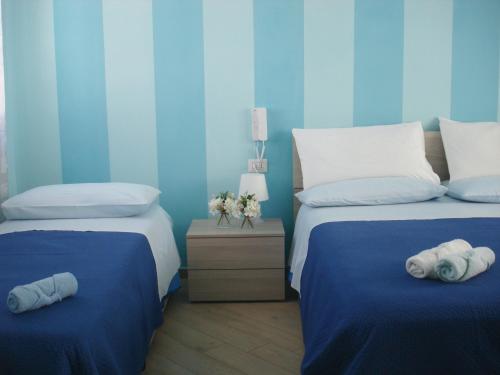a blue bedroom with two beds with towels on them at B&B Margherita in Marina di Camerota