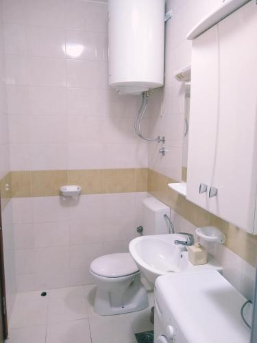 a white bathroom with a toilet and a sink at Kotor Sveti Stasije Mila in Dobrota