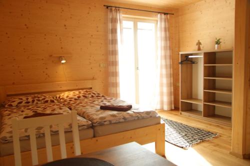 a bedroom with a bed in a wooden room at Ubytování U Křížku in Modrava