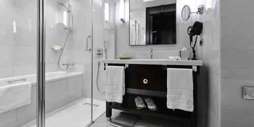 a white bathroom with a sink and a shower at Crowne Plaza Bursa Convention Center & Thermal Spa by IHG in Bursa
