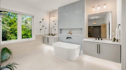 a white bathroom with two sinks and a tub at Siesta Sun Sets in Siesta Key