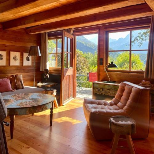 ein Wohnzimmer mit einem Sofa und einem Tisch in der Unterkunft Captivant Chalet T3 vue Panoramique, Chamonix Mont-blanc in Les Houches
