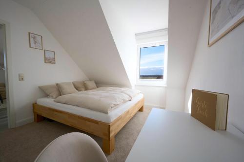 ein kleines Schlafzimmer mit einem Bett und einem Fenster in der Unterkunft Strand in Sicht in Börgerende-Rethwisch